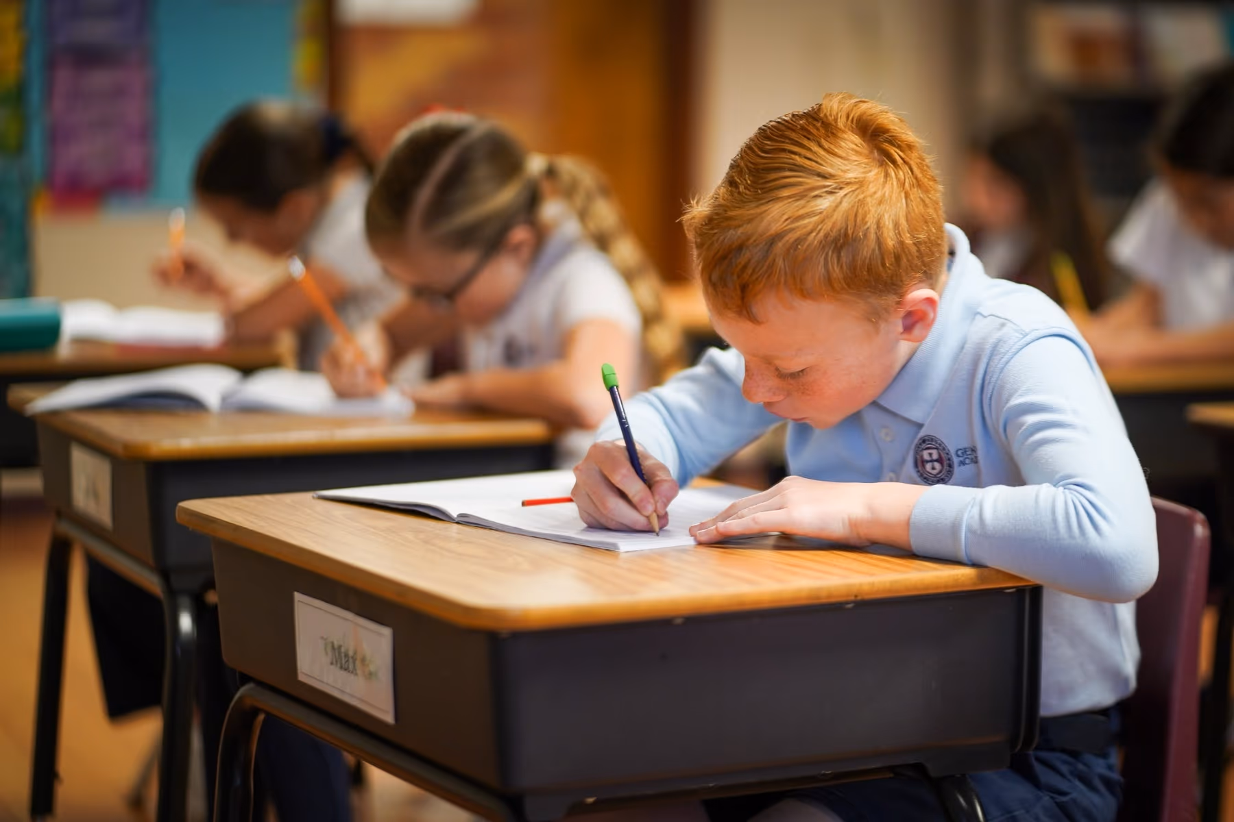 A Geneva Academy student writing at his desk in Roseburg, Oregon